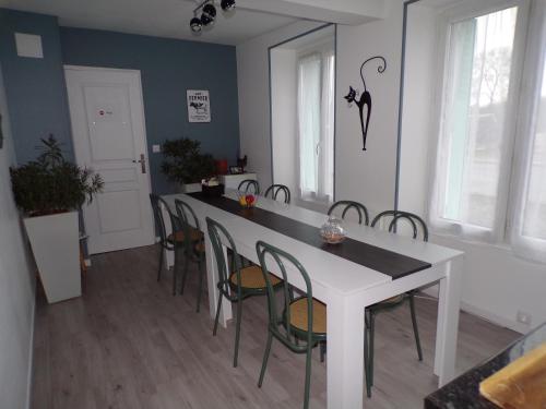 una sala da pranzo con tavolo e sedie bianchi di A la Belle Etoile a Méry-sur-Cher