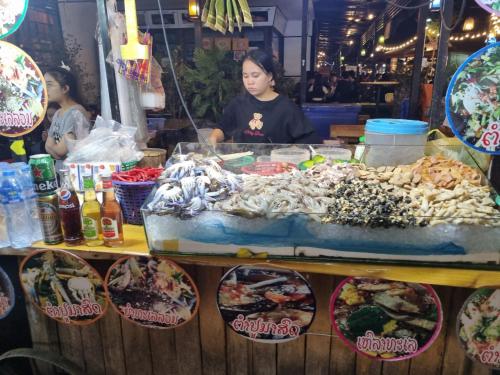 a woman standing behind a table with a buffet of food at khampiane hotel in Ban Nongdouang