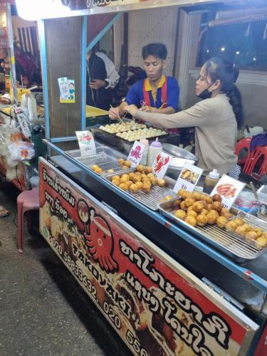 a couple of people standing at a food stand at khampiane hotel in Ban Nongdouang