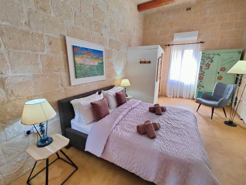 una camera da letto con un letto, due lampade e una sedia di Gawhra B&B a Victoria