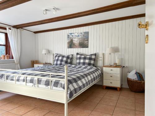 - une chambre dotée d'un lit avec un cadre blanc dans l'établissement Reetkate Reetdachhaus Friesen Chalet, à Tating