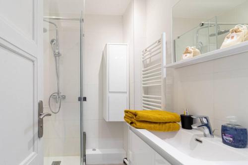 a white bathroom with a sink and a shower at ZenBNB / Safari / 3 Personnes / 5 secondes du Tram in Ambilly