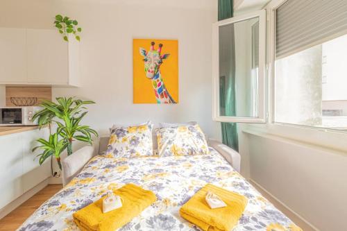 um quarto com uma cama com toalhas amarelas em ZenBNB / Safari / 3 Personnes / 5 secondes du Tram em Ambilly