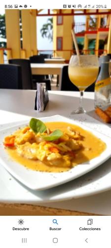a plate of food on a table with a drink at Cabañas y Restaurante Miss Elma in Providencia