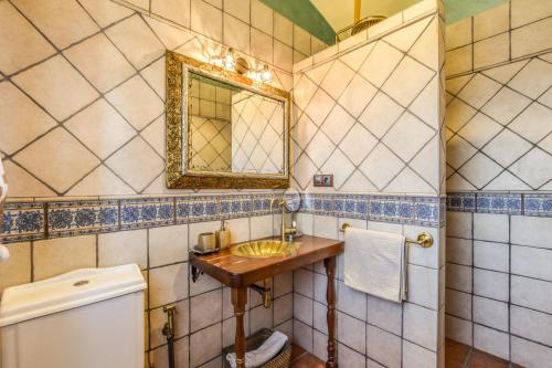 a bathroom with a sink and a mirror and a toilet at Casa del Trotamundos in Villamayor de Campos