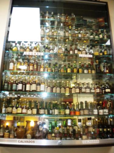 a display case filled with lots of different types of alcohol at Logis Hotel Restaurant Remotel in Knutange