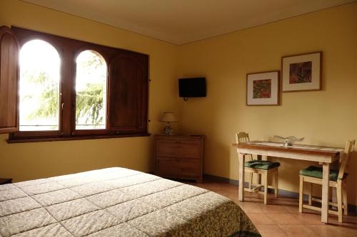 a bedroom with a bed and a desk and a window at Casa Vacanze Le Muse Sillico in Pieve Fosciana