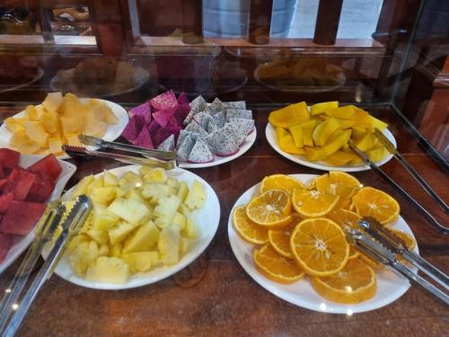 a table with four plates of fruit on it at Khampiane1 Hotel in Ban Nongdouang
