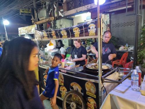 a group of people standing around a food cart at Khampiane1 Hotel in Ban Nongdouang