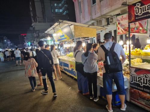 a group of people standing at a market at night at Khampiane1 Hotel in Ban Nongdouang