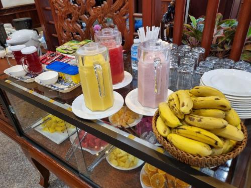 a table with a bunch of bananas and jars of juice at Khampiane1 Hotel in Ban Nongdouang
