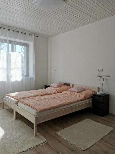 ein Schlafzimmer mit einem großen Bett in einem weißen Zimmer in der Unterkunft Lizi Apartman in Harkány