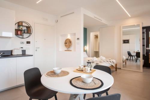 una cucina bianca e una sala da pranzo con tavolo e sedie bianchi di Gentile 46 Blu Luxury Flat a Bari
