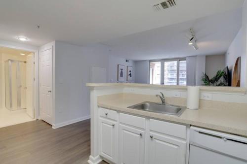 eine Küche mit weißen Schränken und einem Waschbecken in der Unterkunft Spacious Apartment With 2 Bedrooms in Arlington