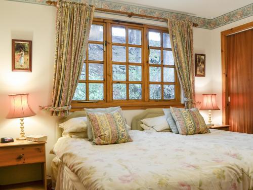 a bedroom with a large bed with a window at Toll Bridge Lodge in Banchory