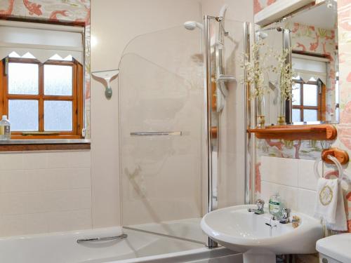 La salle de bains est pourvue d'une douche et d'un lavabo. dans l'établissement Toll Bridge Lodge, à Banchory