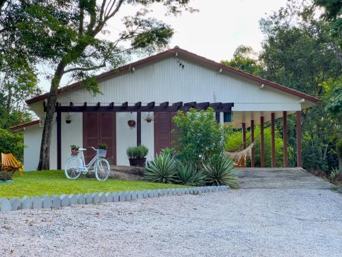 a house with a bike parked in front of it at Seu Refúgio Rural Piscina Privativa e Natureza in Tubarão