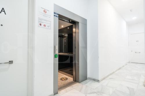 una porta aperta in una stanza bianca con porta a vetri di Elegant studio in the heart of Malaga by REMS a Málaga