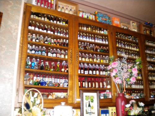 a cabinet filled with lots of bottles of alcohol at Logis Hotel Restaurant Remotel in Knutange