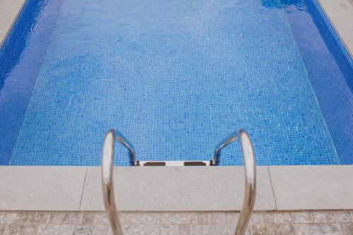 a swimming pool with two metal chairs next to it at Casa da Morena by Amazing Madeira in Santa Cruz
