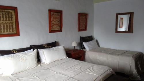 1 dormitorio con 2 camas y mesa con lámpara en Posada Agua Pampas en Villa Ventana