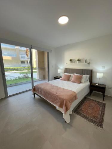 una camera con un grande letto e una grande finestra di Exclusivo apartamento frente al mar a San Pedro de Macorís