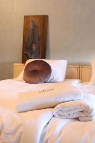 a bed with two towels and a pillow on it at Porcus Campus in Aarle-Rixtel