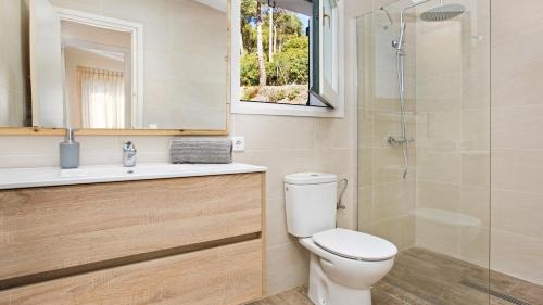 a bathroom with a toilet and a sink and a shower at La vinya in Palafrugell