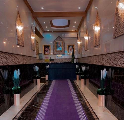 a hall with a purple aisle in a church at Najma ApartHotel in Jeddah
