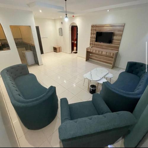 sala de estar con sofás azules y piano en Najma ApartHotel en Yeda