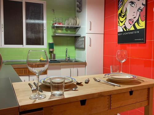 a kitchen with a wooden table with wine glasses at Tati flat - "Parking Fácil" in Córdoba