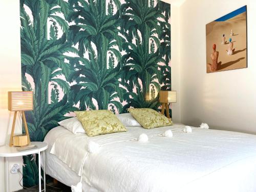 a bedroom with a large bed with a green and white wallpaper at La Siesta in La Rochelle