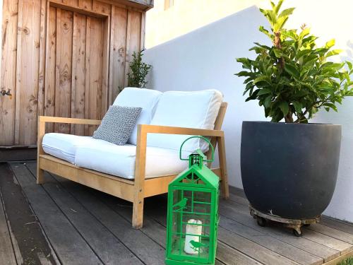 una pequeña linterna verde sentada junto a un sofá en un patio en La Siesta, en La Rochelle