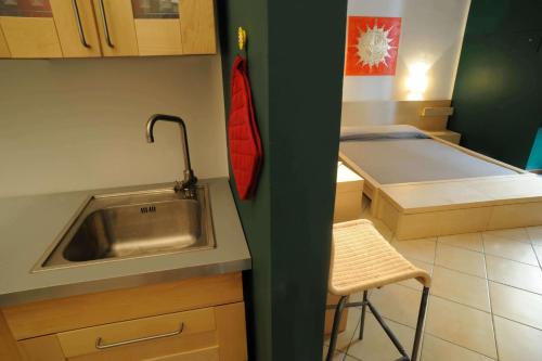 cocina pequeña con fregadero y cama en Al Vicolo Palermo, en Palermo