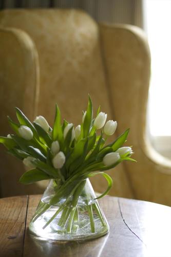 a vase filled with white flowers on a table at The Manor at Sway – Hotel, Restaurant and Gardens in Sway