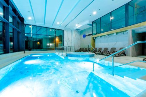 a large swimming pool in a building at Apartamenty The View Hevenia in Rewal