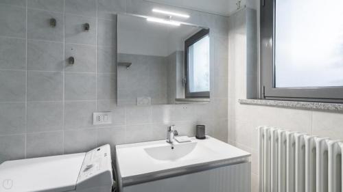 a bathroom with a sink and a mirror and a radiator at Casa Olimpia in Bresso