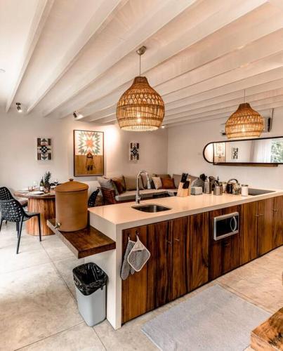 a kitchen with a sink and a living room at BoHo Home in Gated Eco Residence marAmar - Top location in Santa Teresa Beach