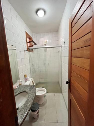 y baño con lavabo y aseo. en DE FRENTE PRA PRAIA Apartamento da Cris Taperapua - Condomínio América Praia Flat, en Porto Seguro