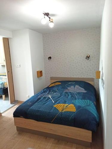 une chambre avec un lit avec une couette bleue dans l'établissement Superbe appartement Trébeurden proche mer, parking, à Trébeurden