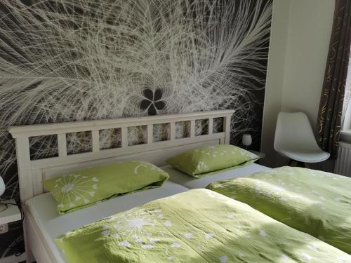 um quarto com 2 camas e almofadas verdes em Gästehaus Arkona em Tönning