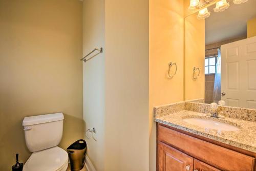 a bathroom with a toilet and a sink and a mirror at Smyrna Vacation Rental about 2 Mi to The Battery! in Smyrna