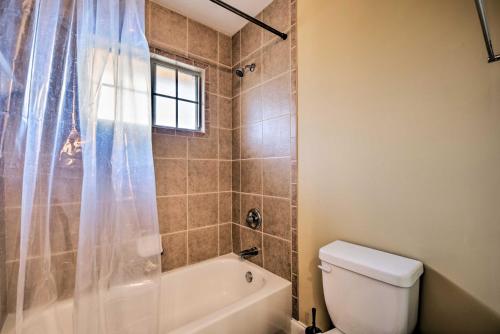 a bathroom with a tub and a toilet and a window at Smyrna Vacation Rental about 2 Mi to The Battery! in Smyrna