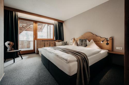 a bedroom with a large bed and a window at Alpenappartements Cristall in Ehrwald