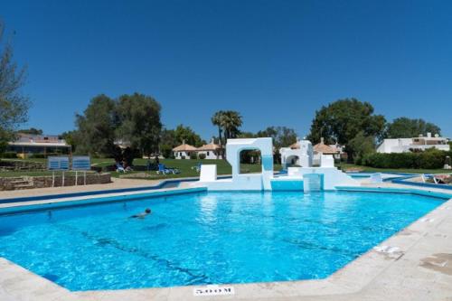 a large swimming pool with blue water at Cosy Beach Loft Pedras Del Rei in Pedras de El-Rei
