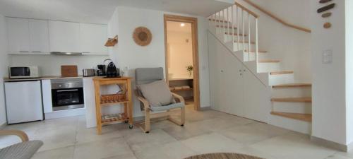 a kitchen with a staircase and a chair in a room at Cosy Beach Loft Pedras Del Rei in Pedras de El-Rei