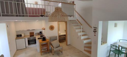 a living room with a staircase and a kitchen with a table at Cosy Beach Loft Pedras Del Rei in Pedras de El-Rei