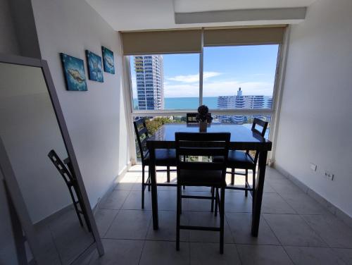 a dining room with a table and chairs and a large window at Apartamentos en Playa Coronado in Playa Coronado
