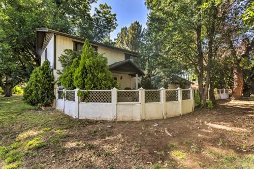 a fence in front of a house with trees at Patio and Yard Dtwn Cottonwood Home! in Cottonwood