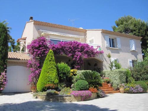 a house with flowers and plants in front of it at Studio dans villa de charme, piscine, proche plage in Cassis